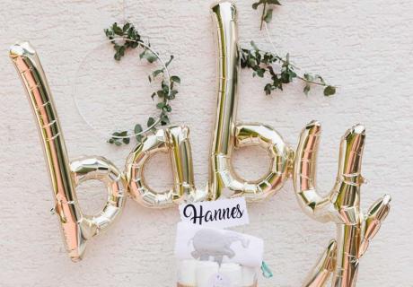 Der stylische "baby" Script Ballon in metallic Gold ist der Eye Catcher über dem Geschenketisch zur Babyparty © juliafashionblonde